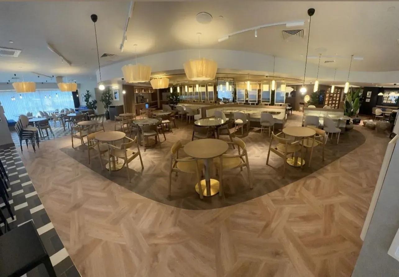 Refurbished Ibis hotel restaurant at West Brompton with luxury vinyl tile parquet flooring sweeping across the dining area in a curved two-tone layout